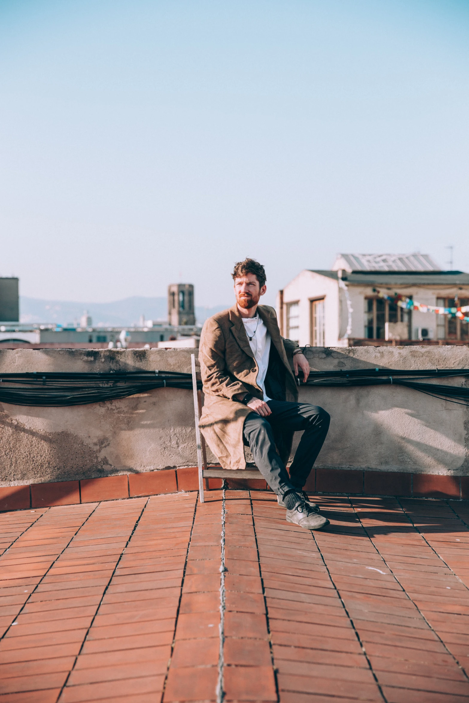 a man sitting on top of a chair next to a building