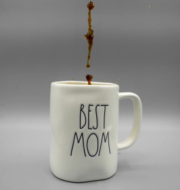 a mug with the text best mom in it being spilled onto the side