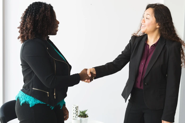 a couple of women standing next to each other holding hands