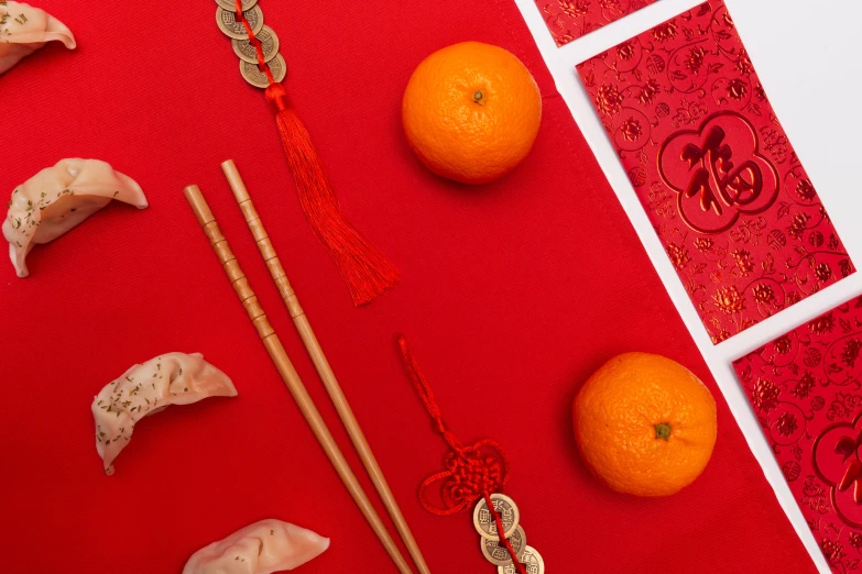 the fruits are on the red table and next to chopsticks