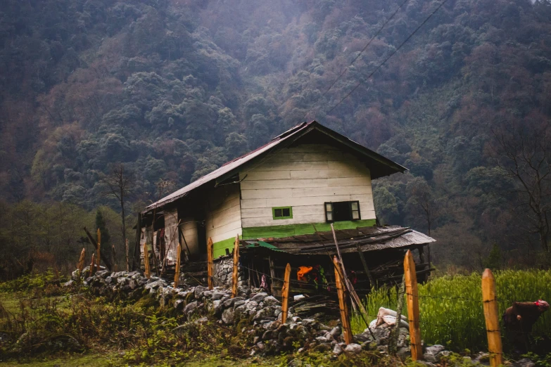 a mountain house surrounded by a stone wall