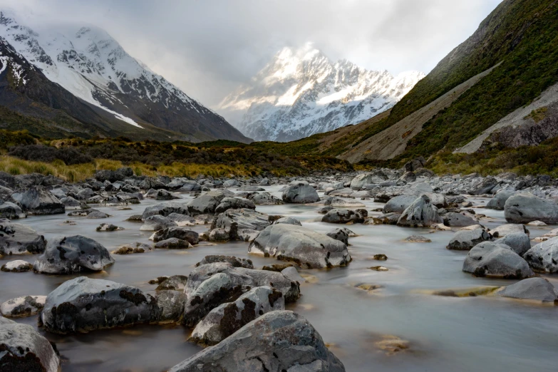 a very pretty river surrounded by mountains in a valley