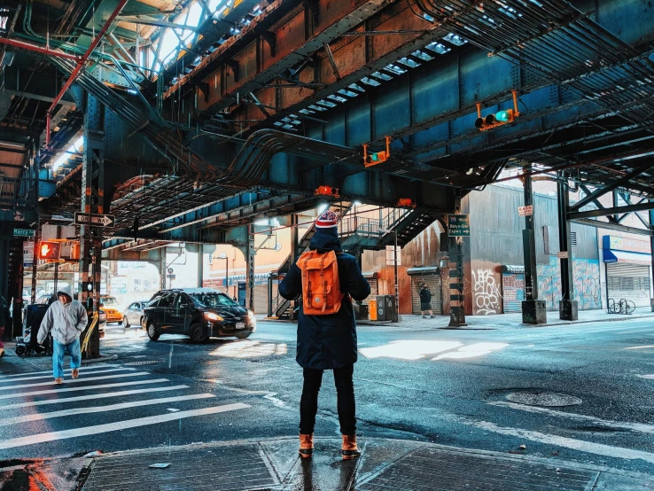 man in orange vest with a laptop bag in an urban setting