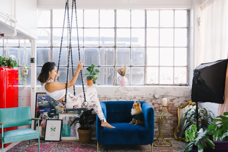 a woman is playing with a dog in a living room