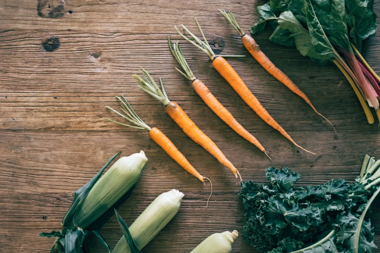 several veggies sitting on top of a wooden table