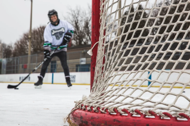 a hockey goalie is approaching the goal and about to take the penalty