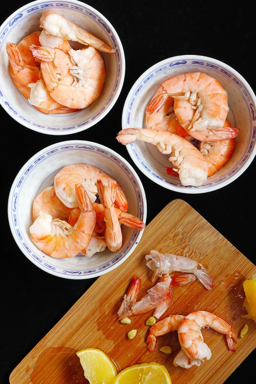 three bowls filled with food sitting on a wooden table