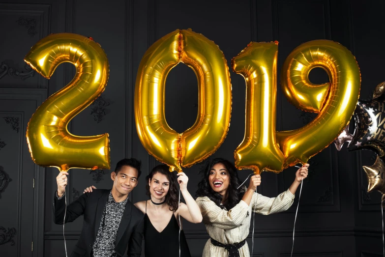 three women and a man pose with their balloons to celete the new year