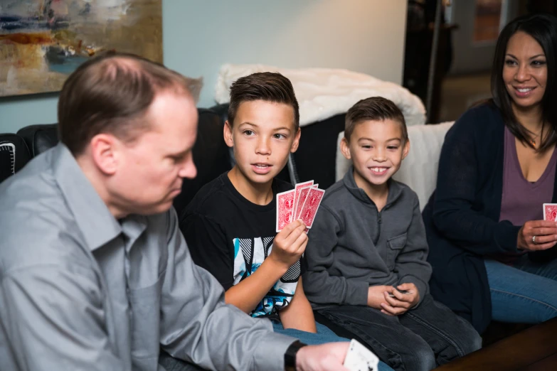 two boys and their mother playing video poker