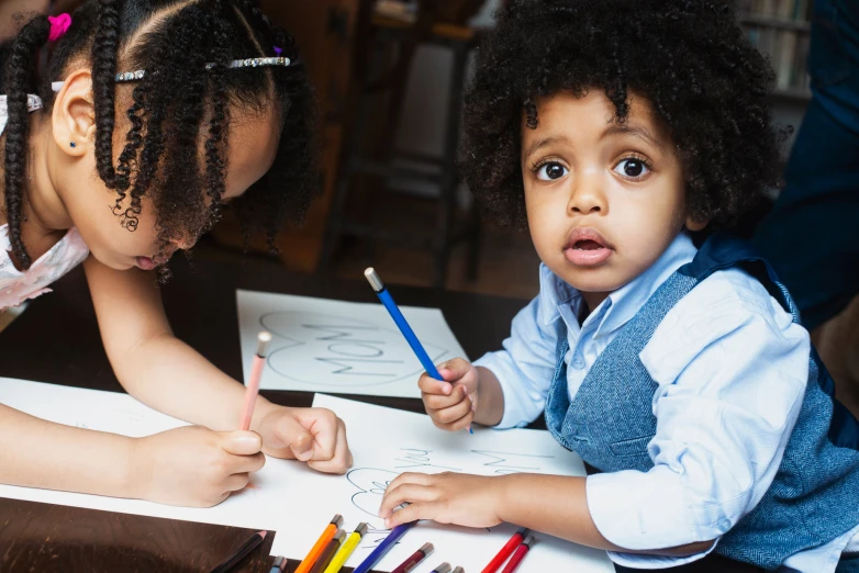 two little girls are in the classroom doing soing