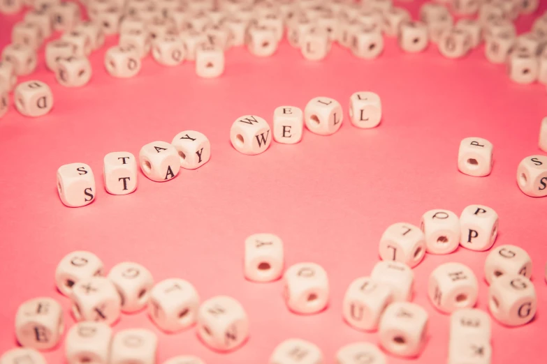 an arrangement of small, white diced, and mixed numbers on a pink background