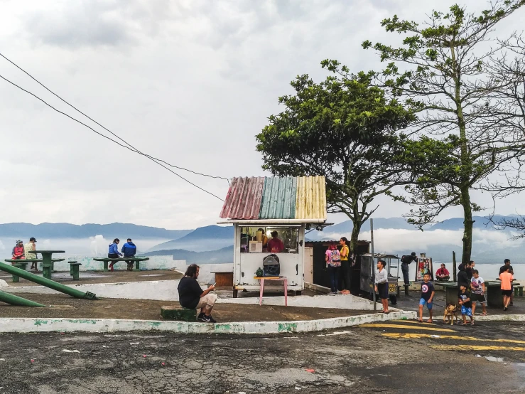 people and a small white house sitting in the middle of nowhere