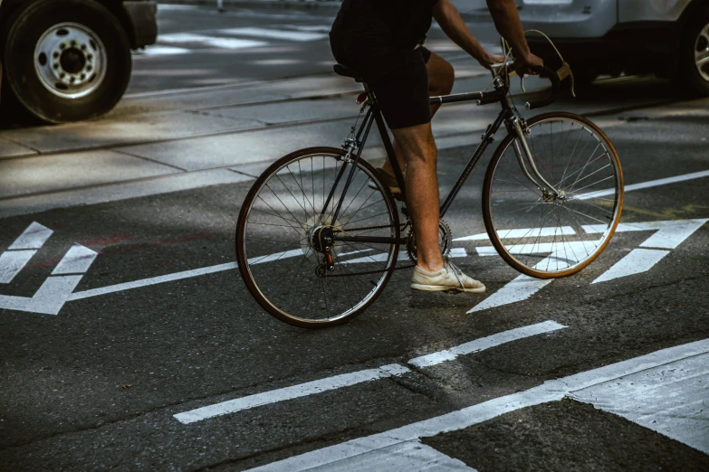 a man riding on the back of a bike across a street