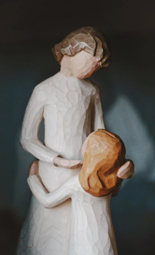 a ceramic figure holding an object with one hand