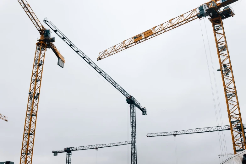 a large building with many cranes standing next to it