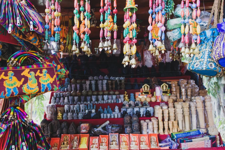 many different colors of beaded necklaces hang on hooks in a store