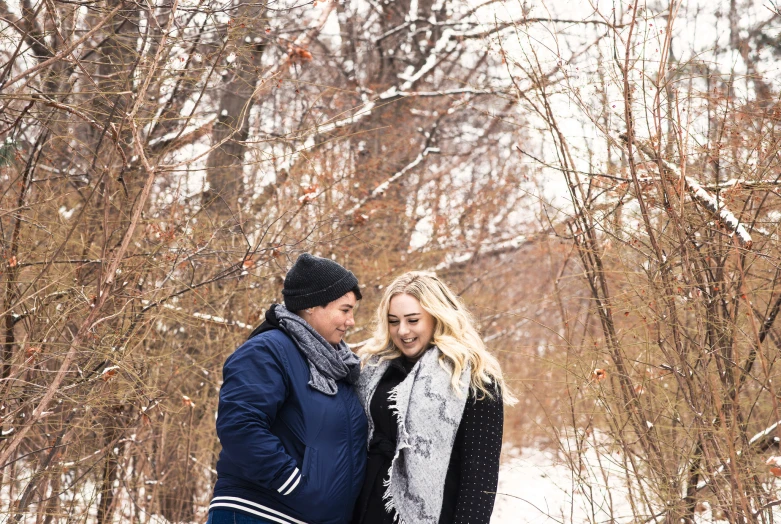 a man and woman are standing by a couple on snow