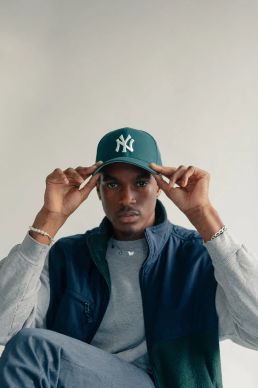 man sitting on chair wearing a new era cap