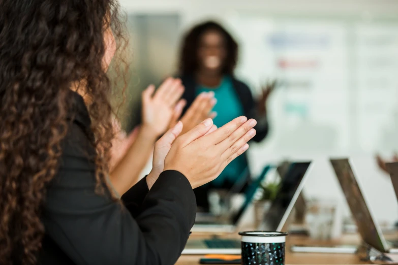 a group of people sitting around a table clapping