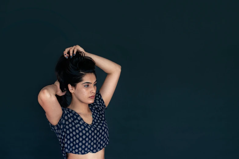 woman in black and white polka dot top scratching her hair