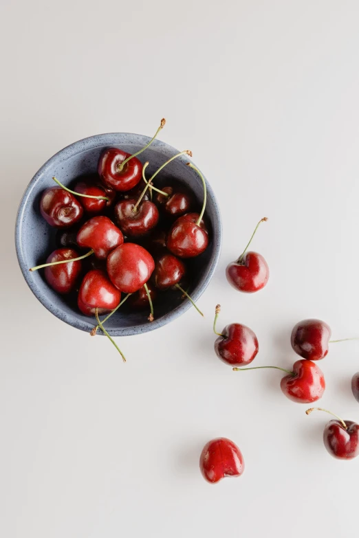 there are several cherries in a blue bowl