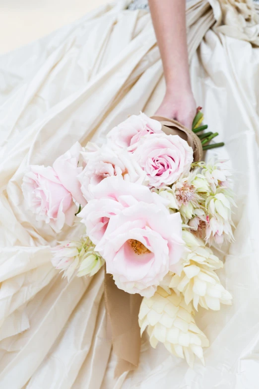 there is a bridal dress and flowers on the floor