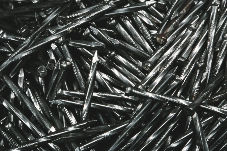 the pile of nails is black and shiny