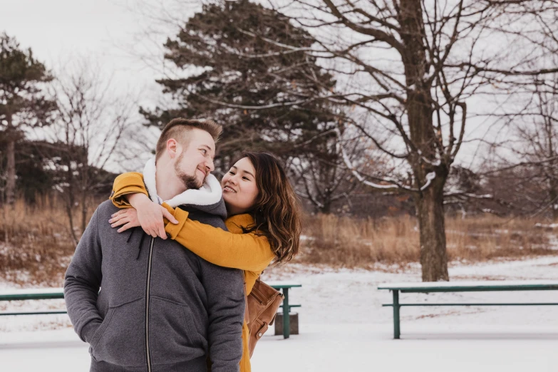 an engaged couple stands together during a winter engagement po session