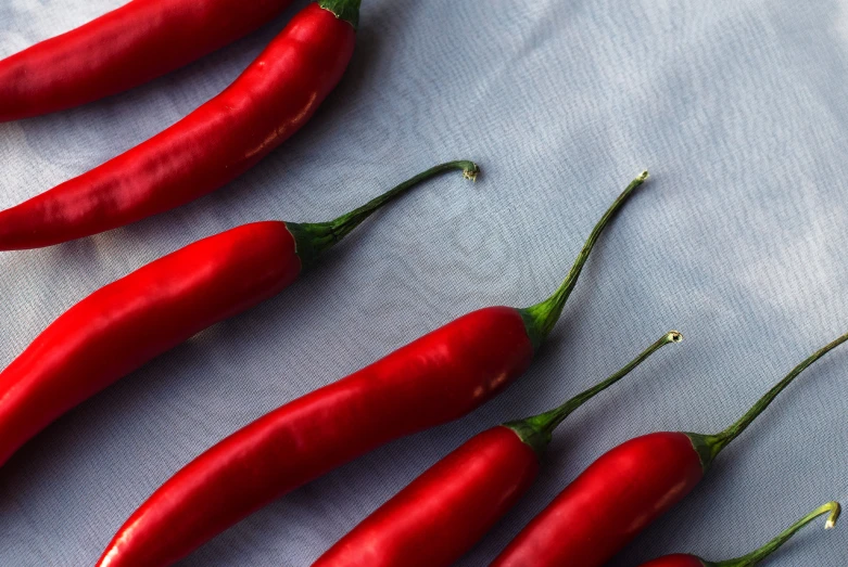 several chili peppers on a blue cloth