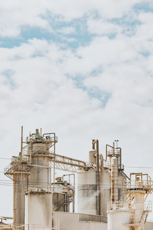 factory structure against a white sky with clouds