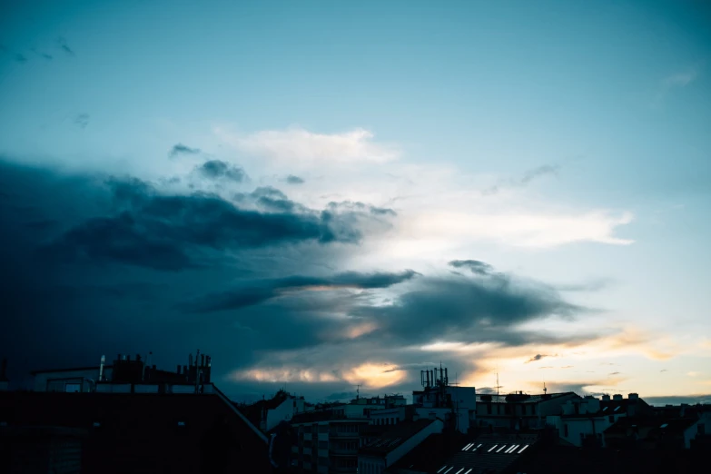 dark clouds over houses in the evening time