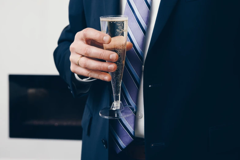 a man in a suit with a glass of champagne