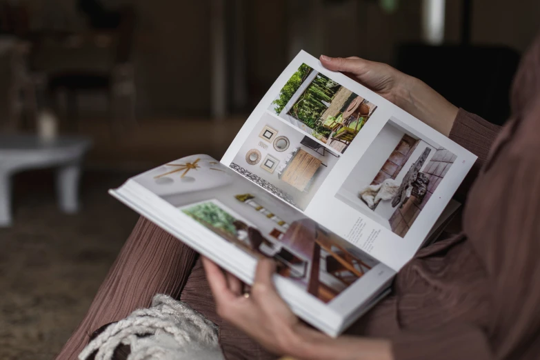 woman holding a white folder with a magazine inside it