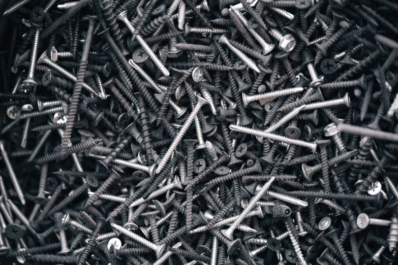 a pile of black screws and pins