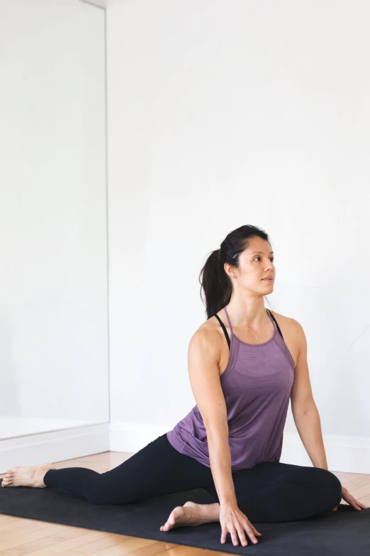 a woman practices yoga on the floor