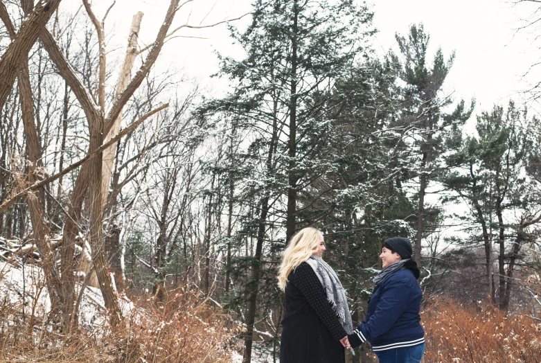 two people walking along the woods during winter