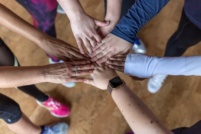 a large group of people reaching their hands together