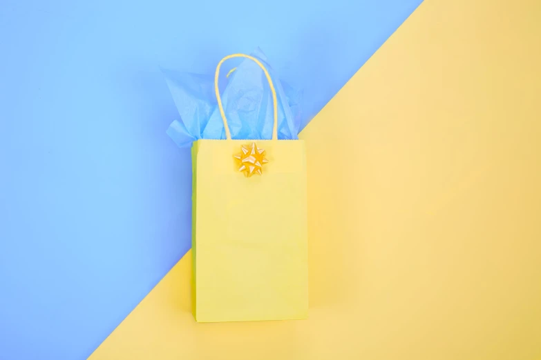 the small yellow paper bag has a flower on top of it