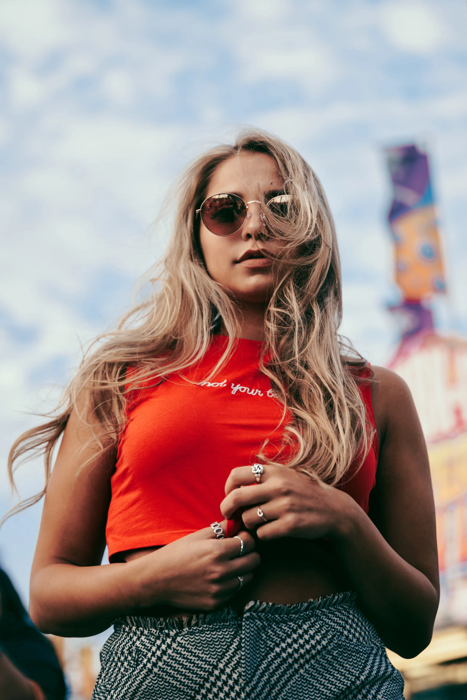 a woman wearing an orange top with some sunglasses on her head