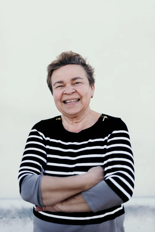 a smiling woman standing with her arms crossed