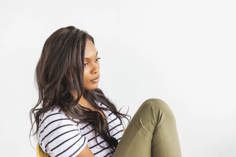 a beautiful young woman sitting on the floor looking down