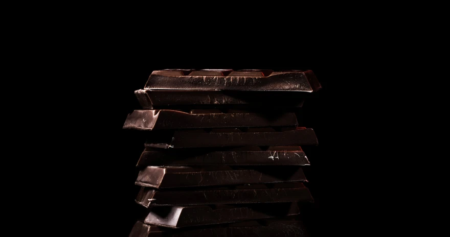 a stack of dark chocolates sitting on top of a black counter