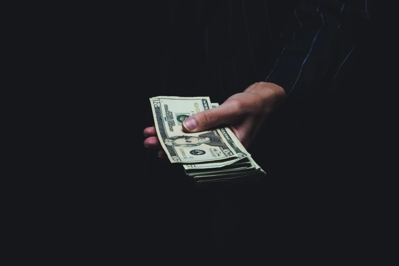 a person holding cash in their hand