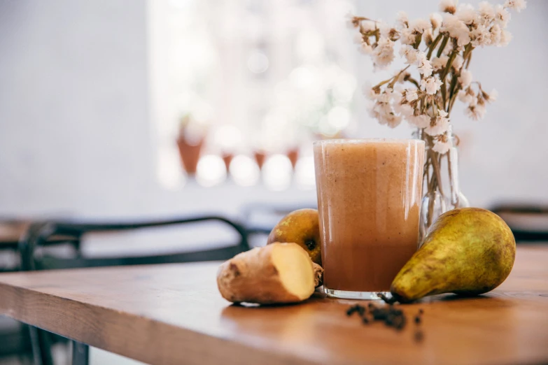 a wooden table topped with a bottle of chocolate and mangoes