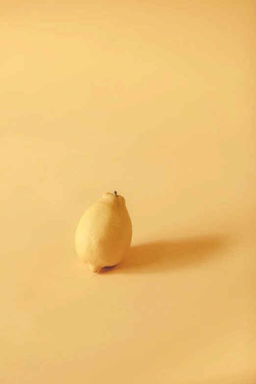 a close up of a lemon on a beige background