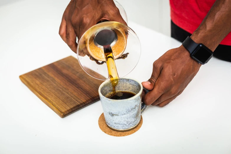 someone pouring beer into a cup with a glass