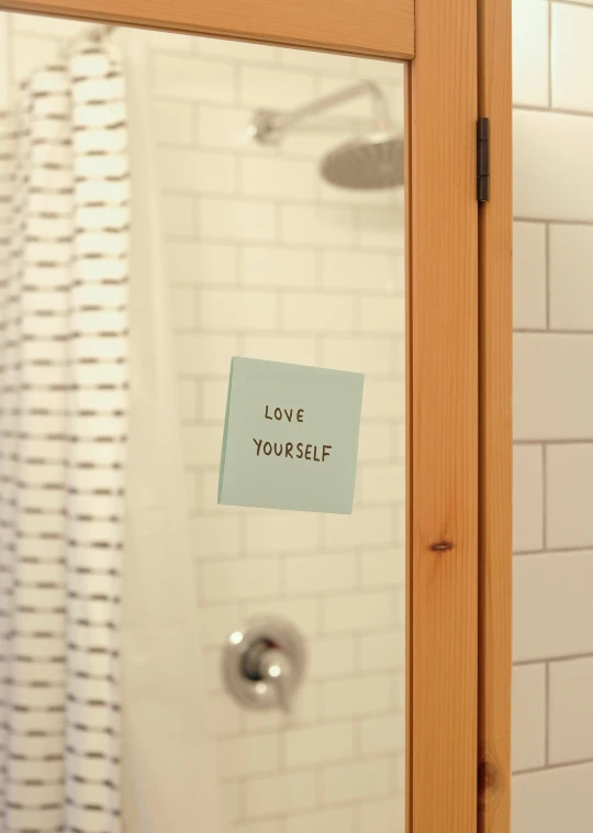 a small note attached to the side of a shower door