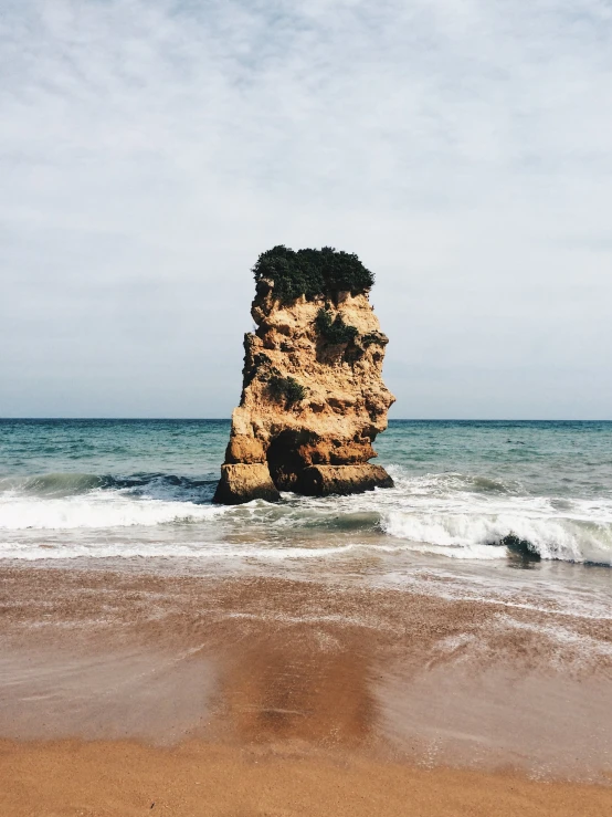 a stone structure in the ocean near a wave