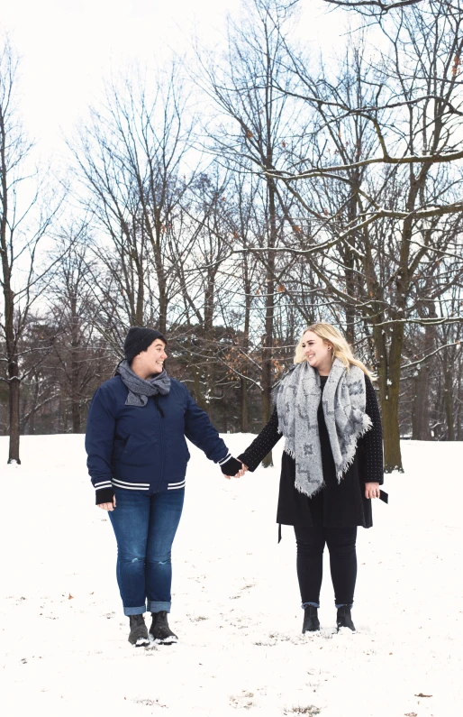 a couple holding hands while walking through the snow