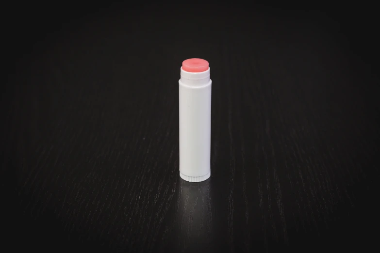 a white lighter sitting on a dark table